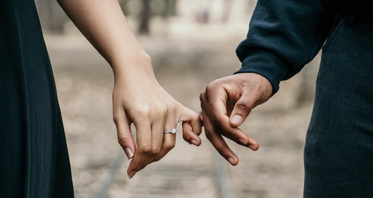 man and woman with pinky finger joined